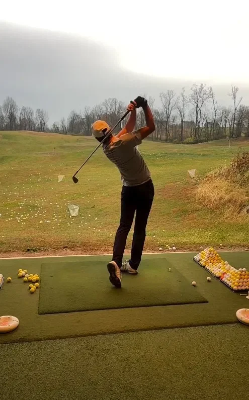 A golfer hitting out onto the grass range